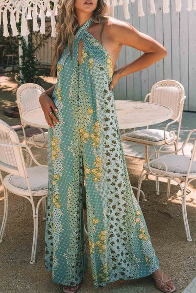 Light blue sleeveless jumpsuit with print, featuring open back and loose trousers.