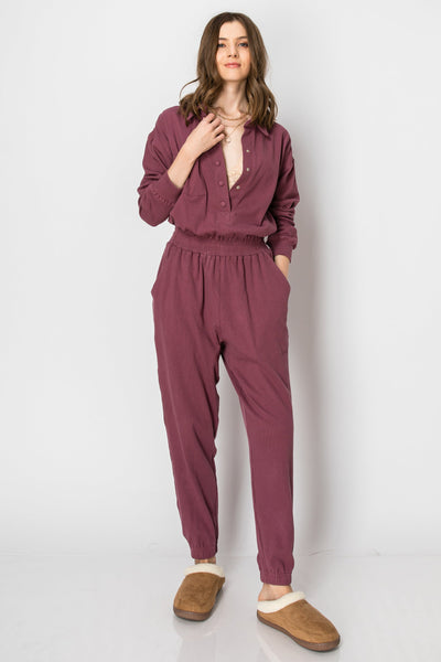 Long sleeve cotton ribbed jumpsuit with snap buttons and collar.